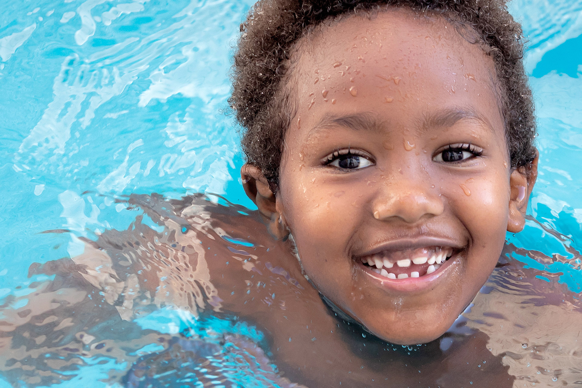 Young child swimming and smiling